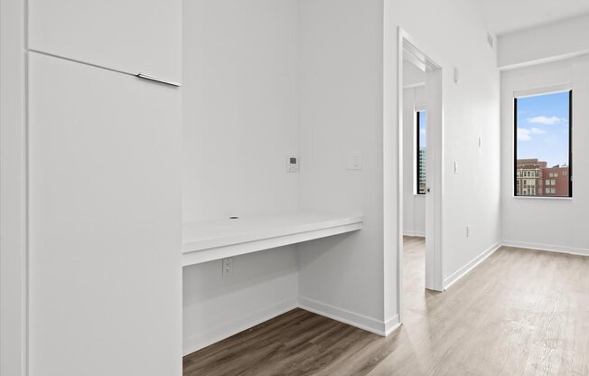 an empty room with white walls and a white refrigerator