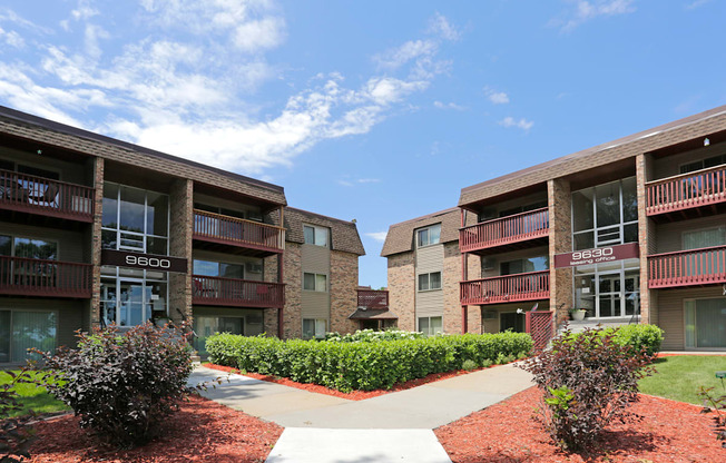 Exterior view of Plymouth Pointe building with split concrete walk path