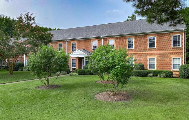 a house with a lawn in front of a brick building