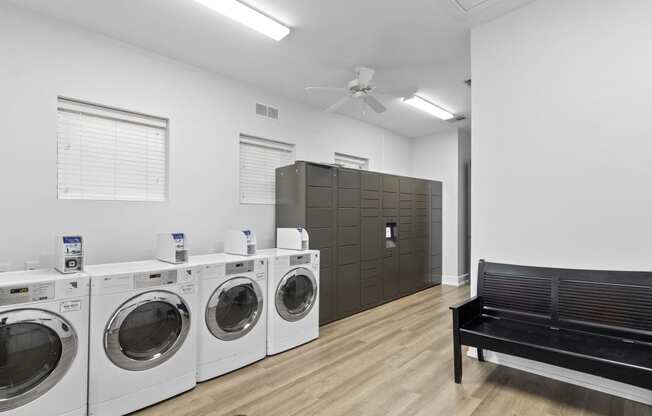 a laundry room with washers and dryers and a bench