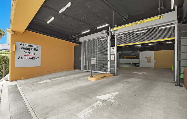 A parking garage for apartments with a sign that says Apartments Leasing Office Parking.