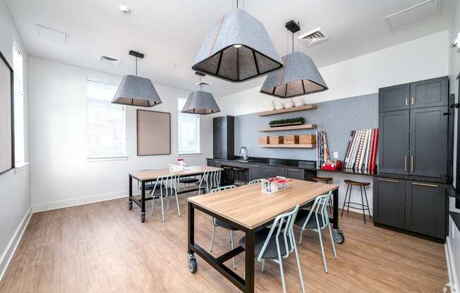 a dining room with tables and chairs and a kitchen at Fairmont at South Lake, Bowie