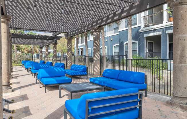 a row of blue benches and tables on a patio