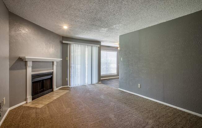 A room with a fireplace and carpeted floor.