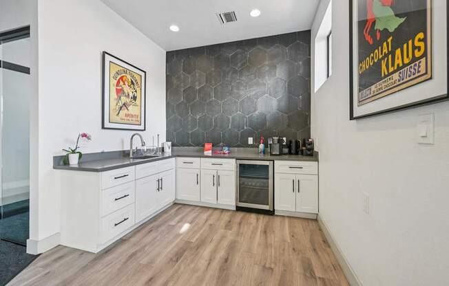 A kitchen with white cabinets and a wooden floor.