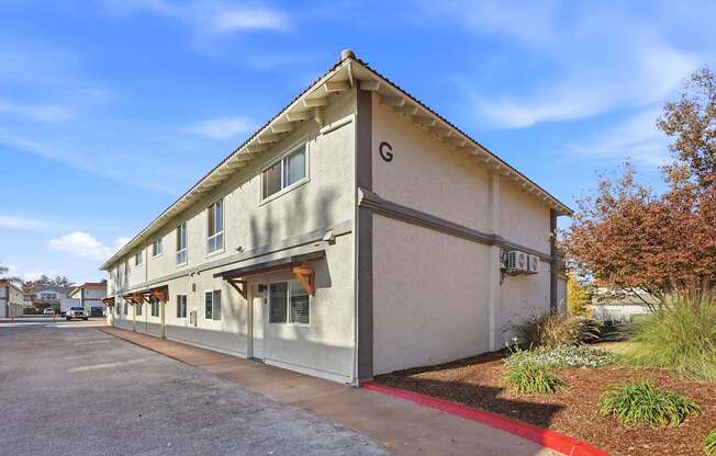 A building with a G on the front is in the sunshine.