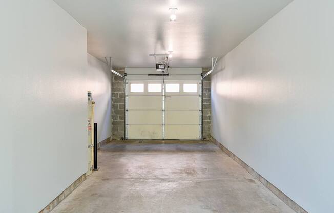 A large, empty room with a concrete floor and white walls.