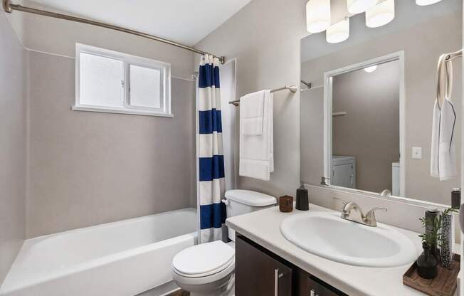 A bathroom with a white tub, toilet, and sink.