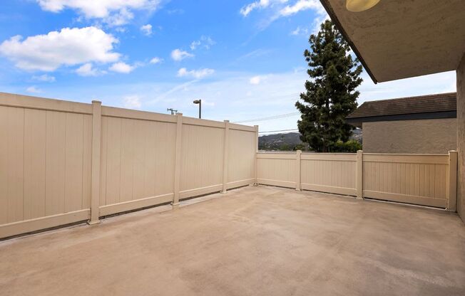 a balcony with a fence and a blue sky in the background
