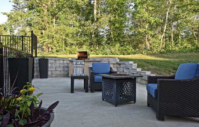 A patio with a table and chairs and a fire pit.