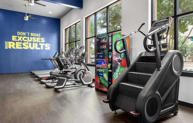 A gym with a row of treadmilers and elliptical machines.