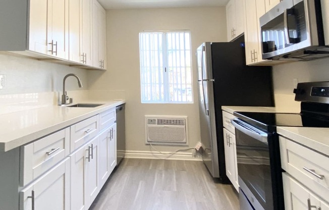 kitchen with stove, sink and fridge