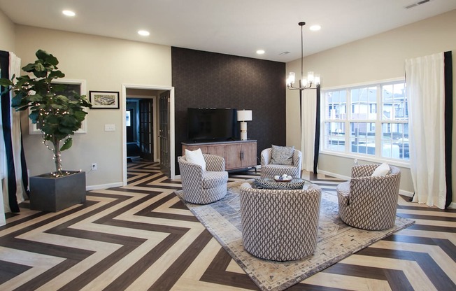 a living room with chairs and a table and a television