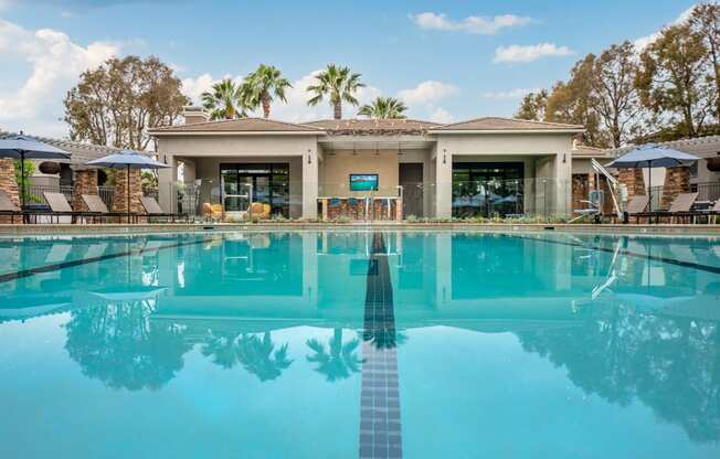 a large swimming pool with a house in the background