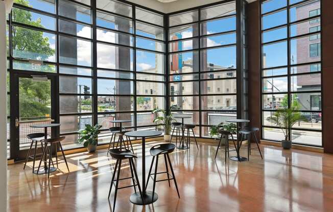 a room with floor to ceiling windows and tables and chairs