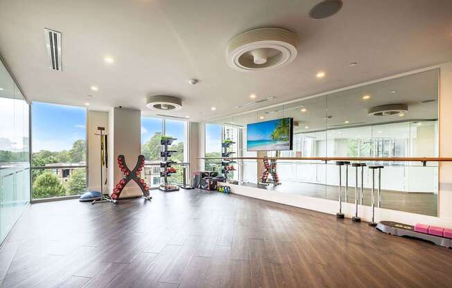 A spacious room with a large screen on the wall and a balcony with a railing.