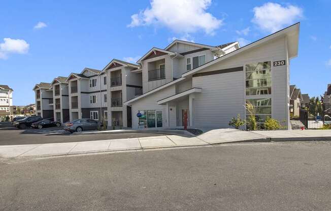 a row of apartment buildings with cars parked in front of them