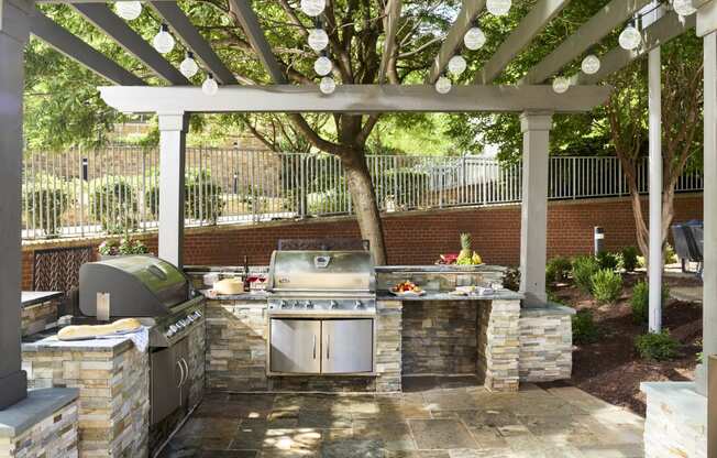 a outdoor kitchen with a grill and a pergola