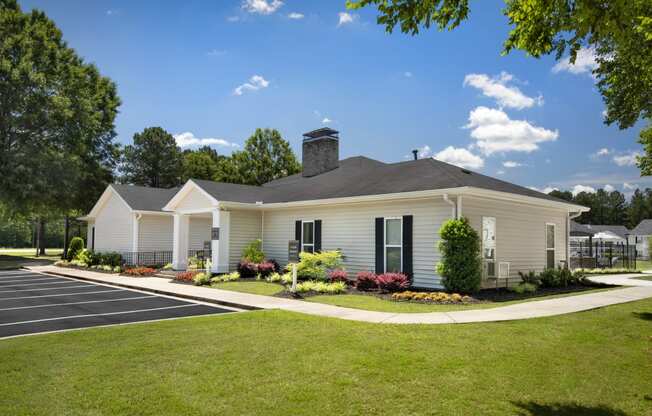 a white house with black shutters and a lawn and a driveway