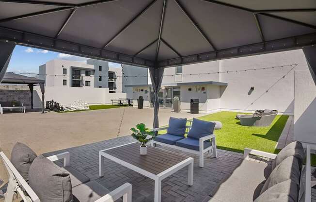 A patio with a table and chairs under a canopy.