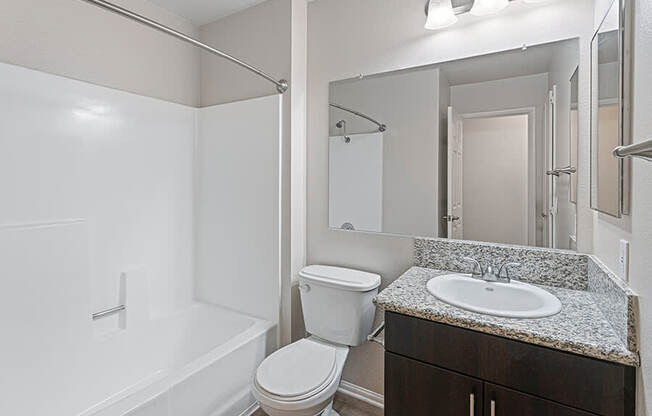 A white bathroom with a toilet, sink, and bathtub.
