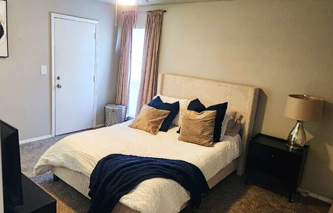 A bedroom with a bed, nightstand, and a ceiling fan.