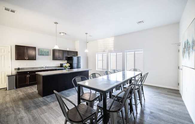 A kitchen with a table and chairs in front of it.