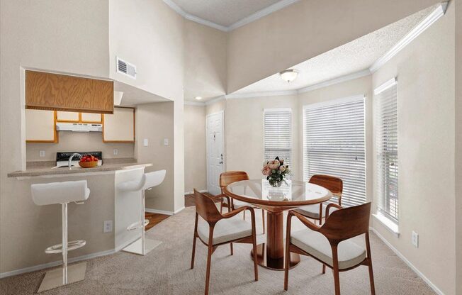 a dining room and kitchen with a table and chairs