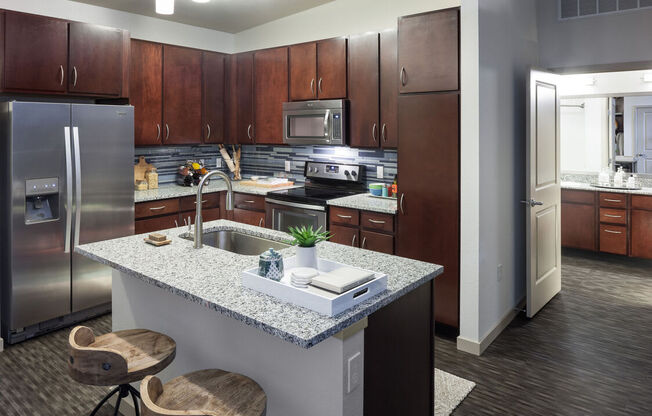 A kitchen with a granite countertop and wooden cabinets.