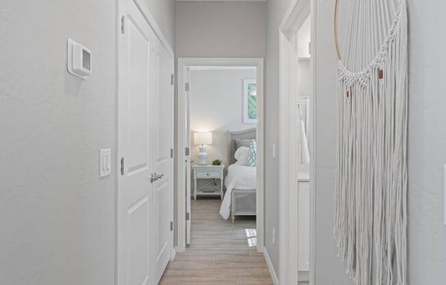 a long hallway with a bed and a white door