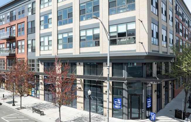 A modern building with a glass facade and a street in front.