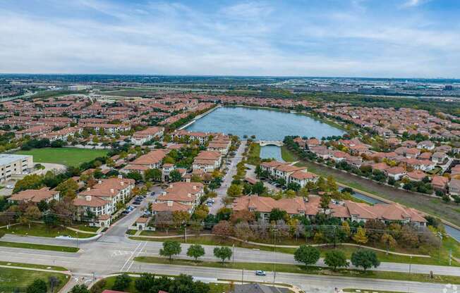 A bird's eye view of a residential area with a lake in the middle.