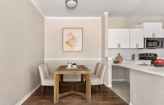A dining table with chairs and a painting on the wall.
