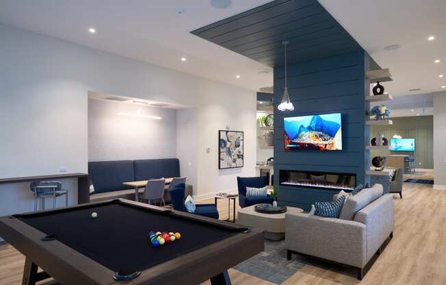 a living room with a pool table and a tv