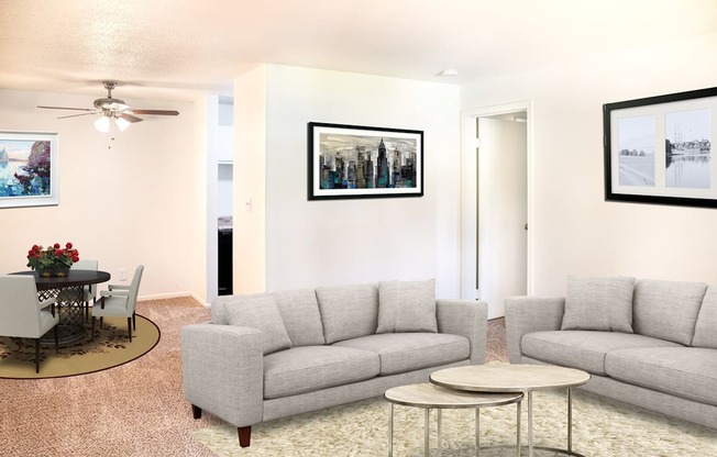 A living room with a grey couch, a coffee table, and a painting on the wall.