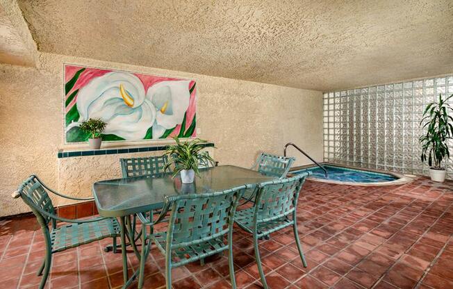 a table and chairs in a room with a pool