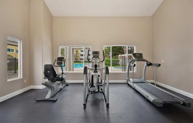 the gym with treadmills and ellipticals at the enclave at woodbridge apartments