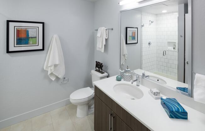 a bathroom with a large mirror and a toilet next to a sink
