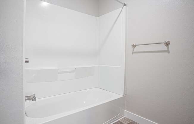 a white bathroom with a tub and a shower curtain