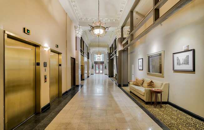 a large hallway with a chandelier and a couch