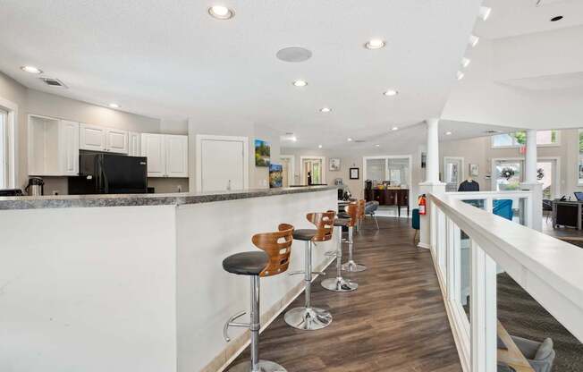 A long white bar with stools and a counter.
