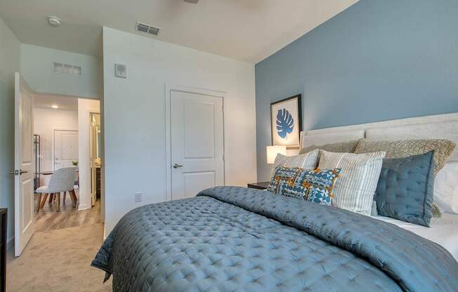 A bedroom with a large bed and a ceiling fan.