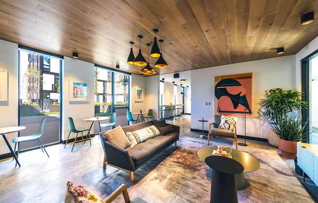 A living room with a black couch and a wooden ceiling.