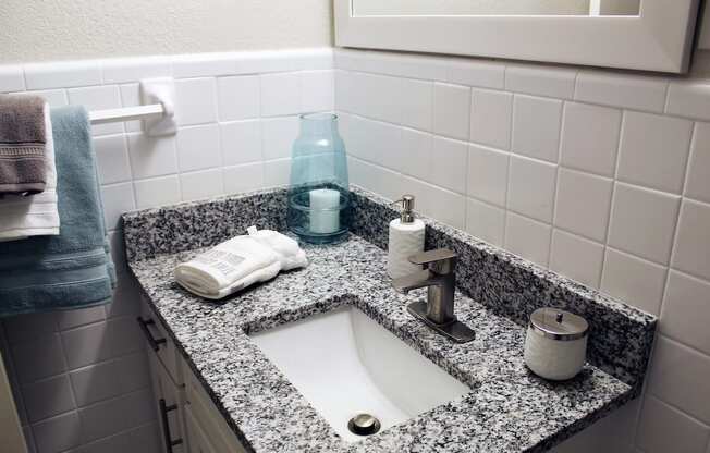 granite vanity in bathroom with under-mount sink, modern fixtures, and tile walls  at Huntsville Landing Apartments, Huntsville, 35806