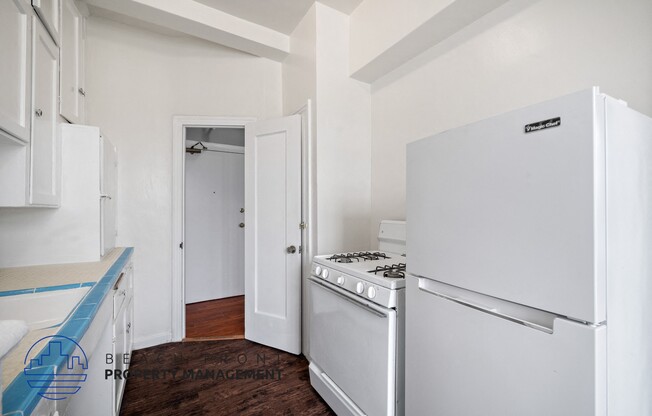 a kitchen with white appliances and white cabinets and a white refrigerator