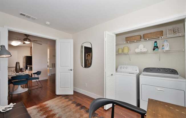 a den with a washer in closet with accordion closet doors 