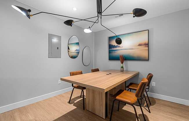 a dining room with a table and chairs and a painting on the wall