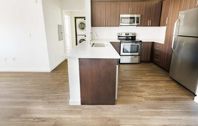 an empty kitchen with wooden cabinets and stainless steel appliances