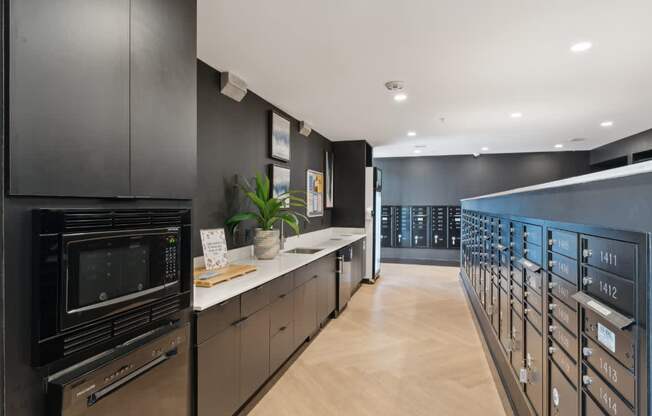 A modern kitchen with black cabinets and wooden floors.