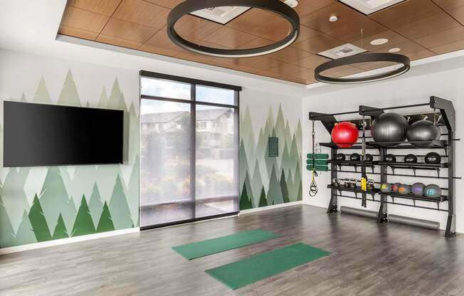 A room with a bowling ball rack and a television.